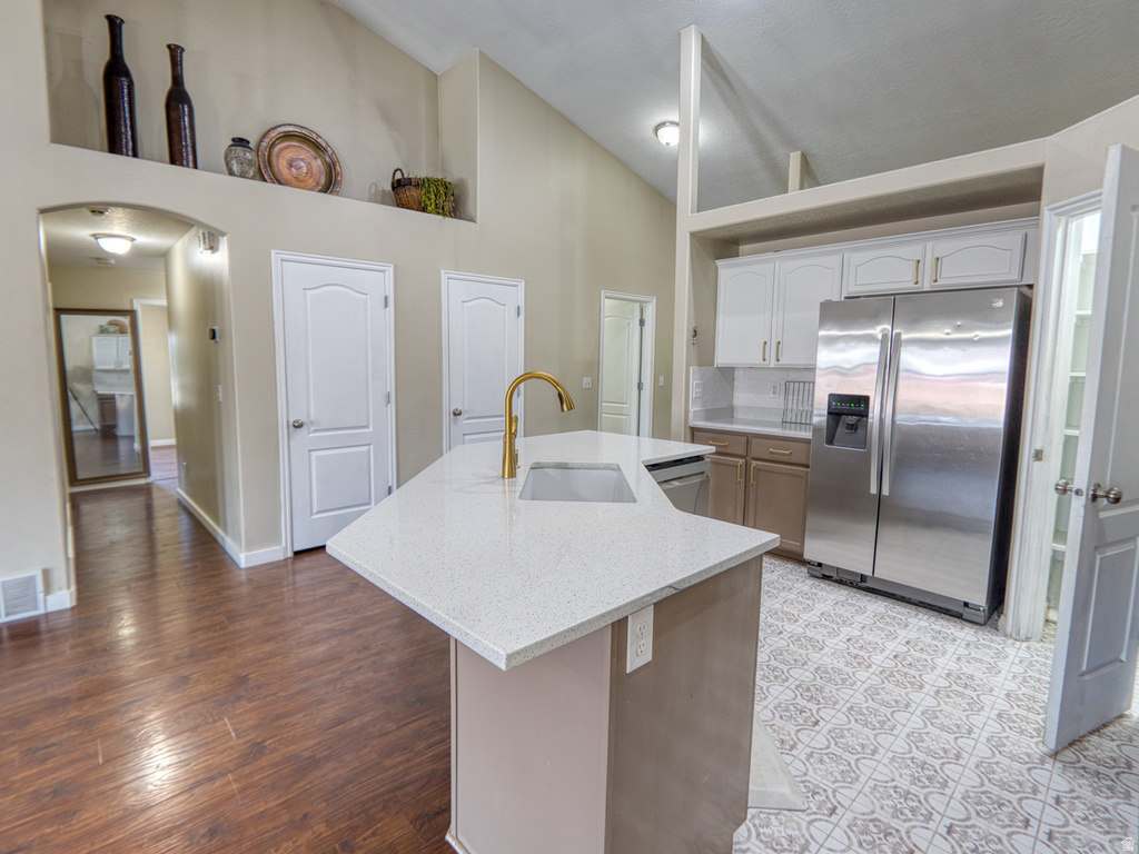Kitchen island with a light-toned countertop and an integrated sink featuring a gold-finish faucet