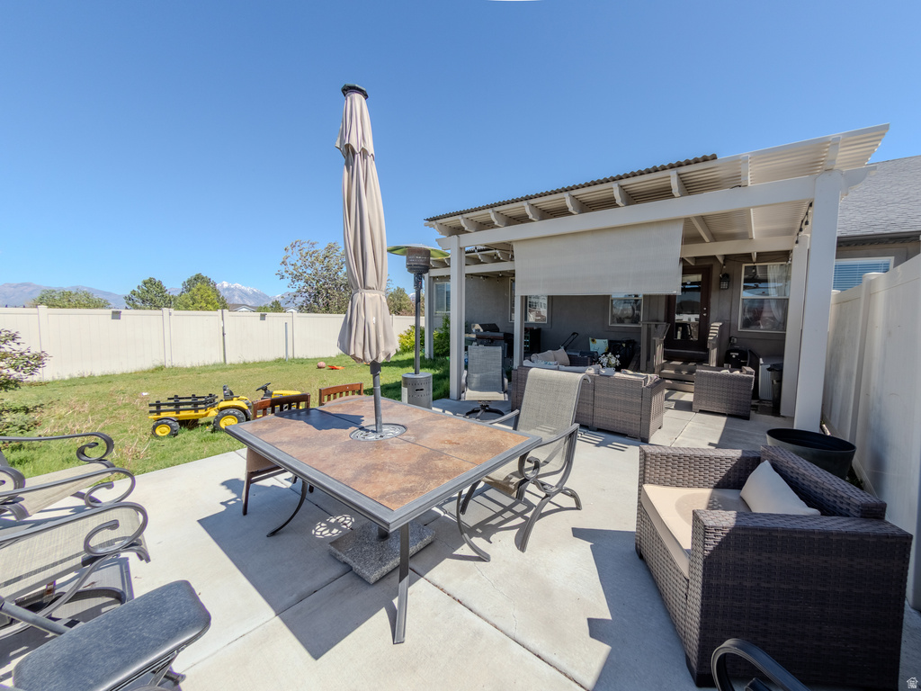 Concrete patio with a multi-level pergola featuring a retractable shade