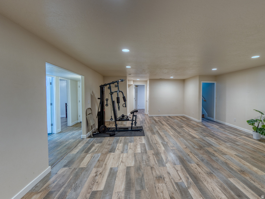Spacious finished area featuring wood-finish flooring, recessed lighting, and neutral wall tones