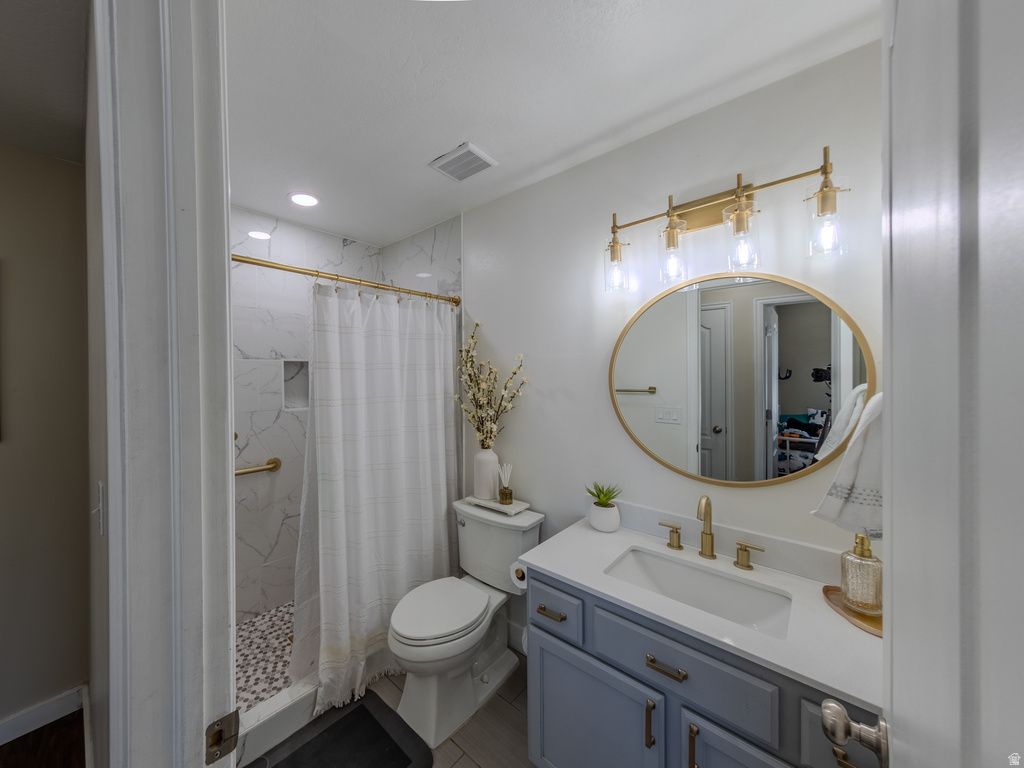 Bathroom featuring a shower with white marble-look tile, pebble flooring, and a built-in niche