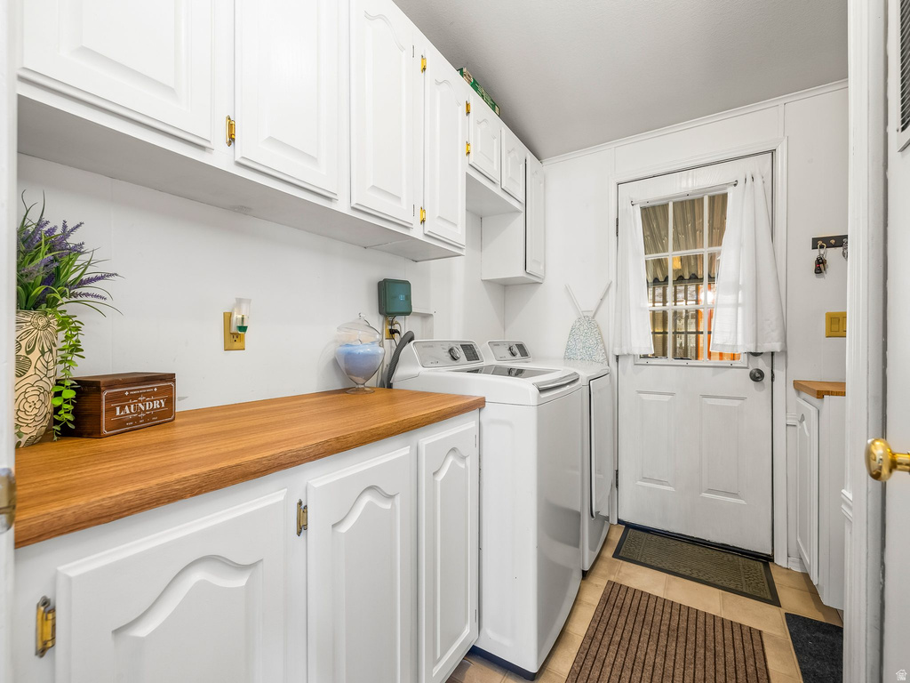 Laundry room featuring built-in white cabinetry, wood-finish countertops, and a paneled entry door with windowpanes