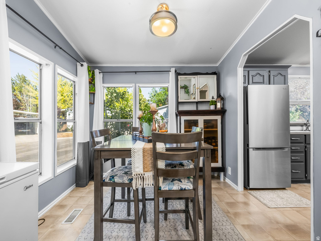 Dining area featuring wood-finish flooring, a contemporary ceiling light fixture, and multiple large windows