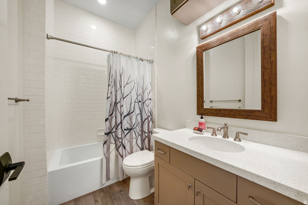 Bathroom featuring a single vanity with stone-finish countertop, undermount sink, and wood-finish cabinetry
