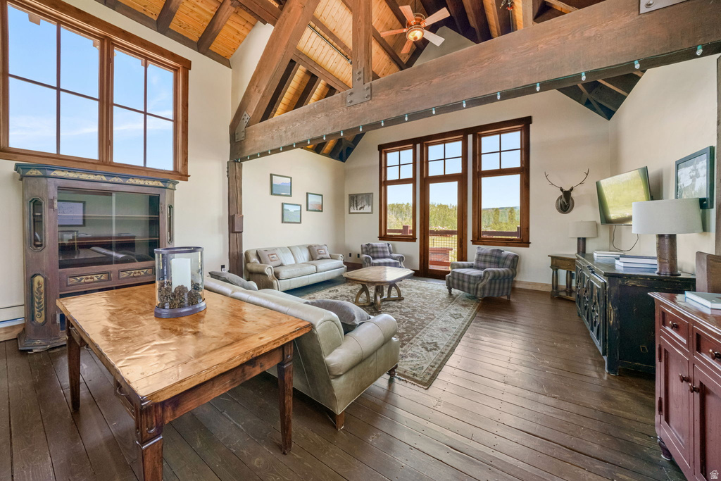 Vaulted wood-beamed ceilings with exposed trusses, large wood-frame windows, and dark wood-finish flooring