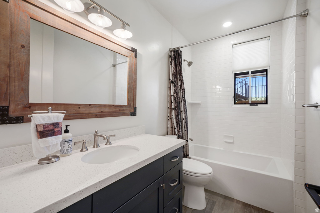 Bathroom featuring a dark wood-finish vanity with a light speckled countertop, an undermount sink, and brushed nickel fixtures