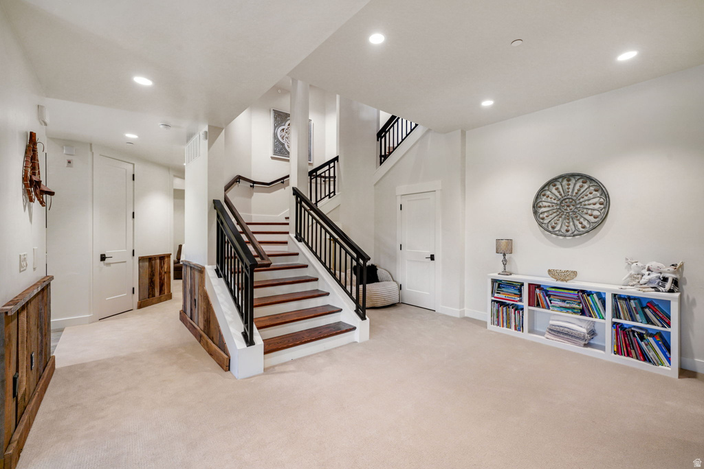 Staircase featuring wood treads, black metal balusters, and a curved wood handrail