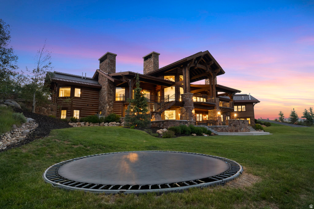 Expansive stone and log construction residence featuring multiple gables and prominent stone chimneys