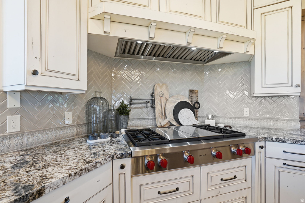Gourmet kitchen featuring a professional-grade stainless steel range with a built-in griddle, complemented by a substantial range hood