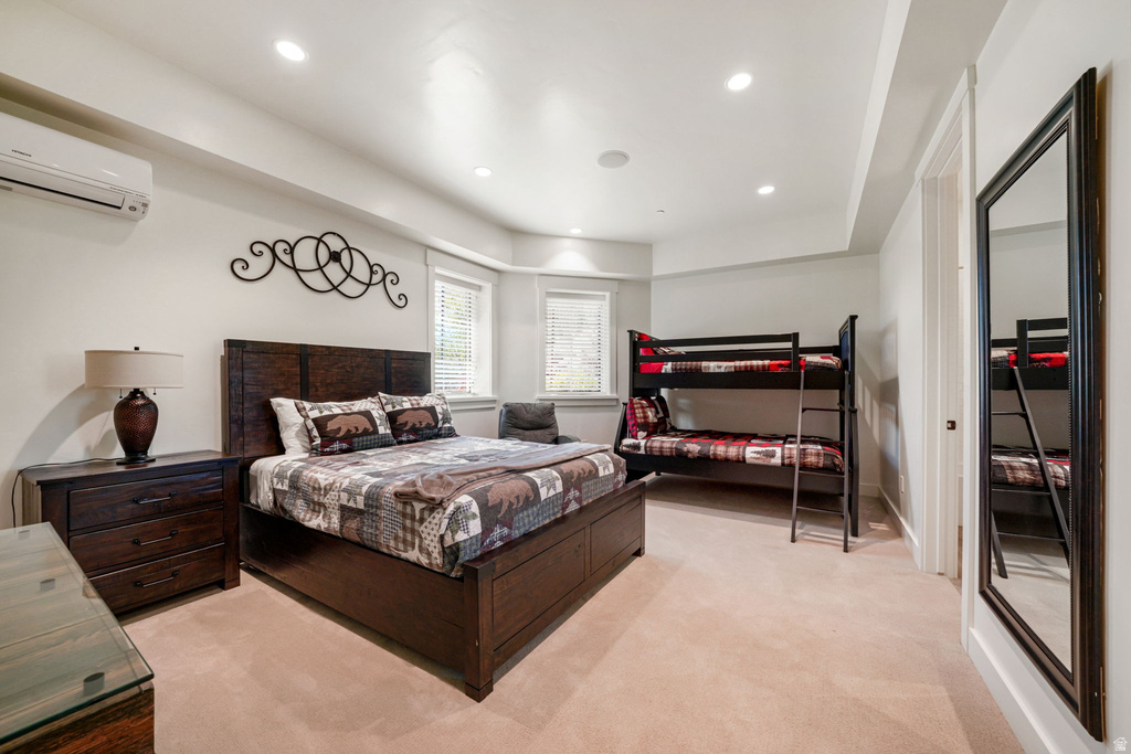 Carpeted room featuring a dark wood bed frame, recessed lighting, and split-unit climate control