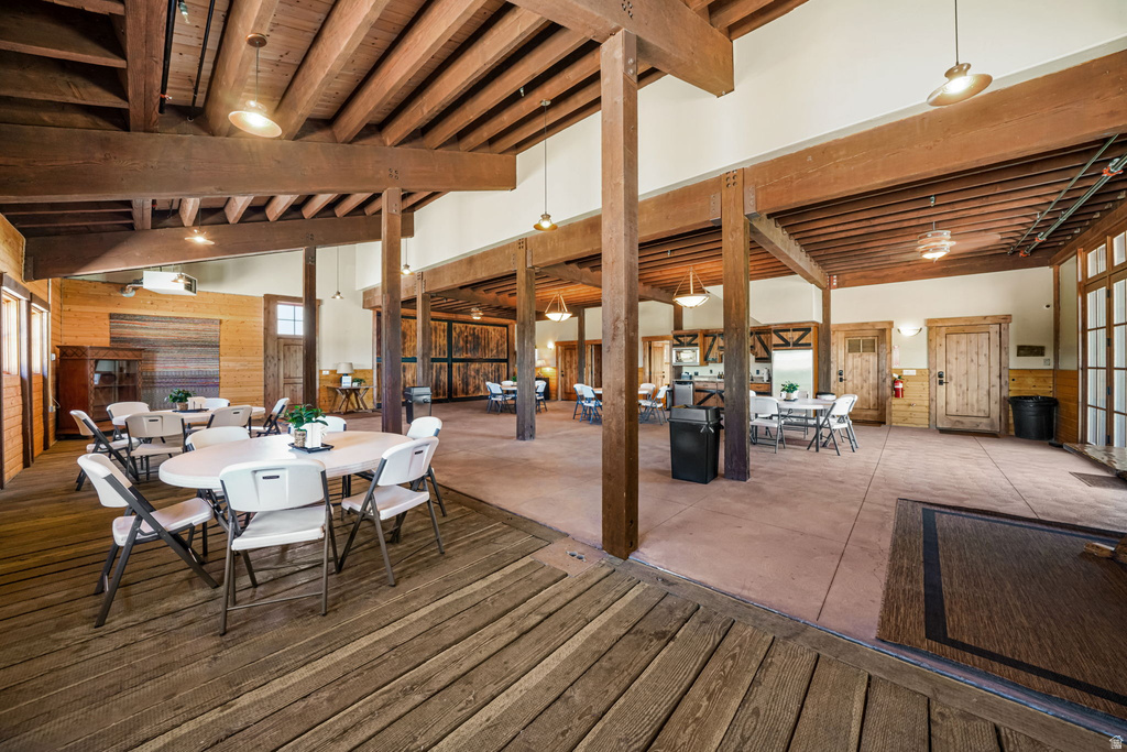 Spacious interior featuring exposed timber beams and columns, wood-finish flooring, light-colored walls, and multiple paneled doors