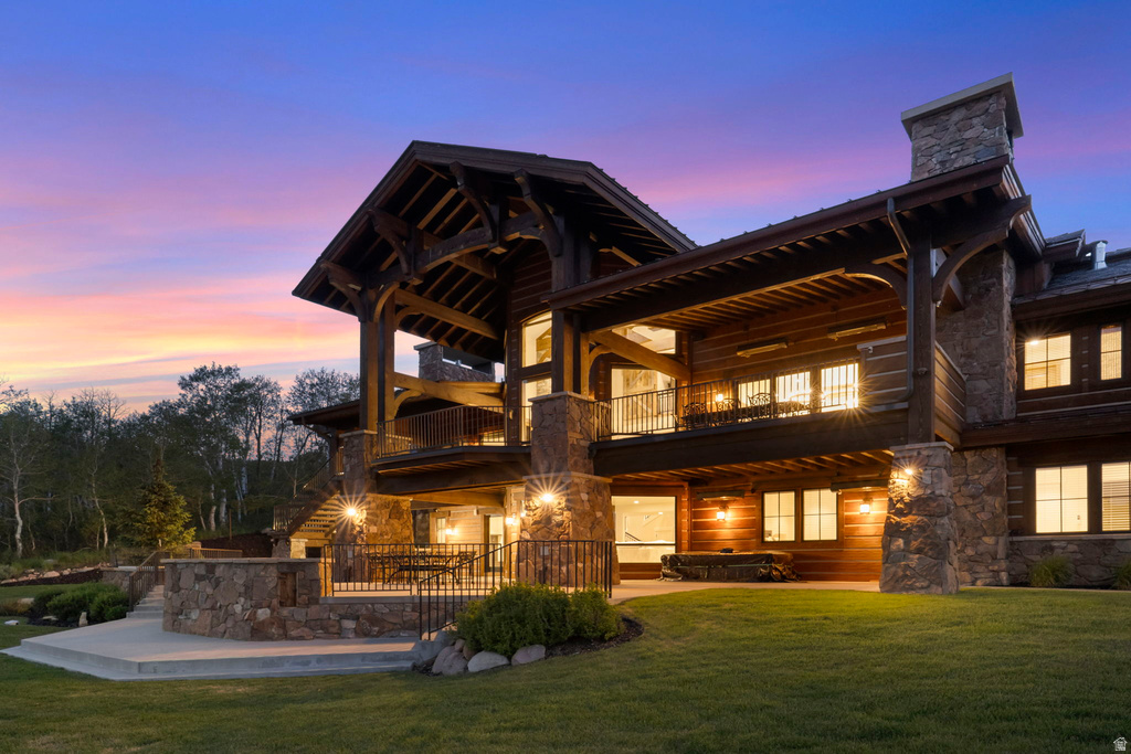 Multi-level stone and wood-sided architectural style featuring a prominent stone chimney