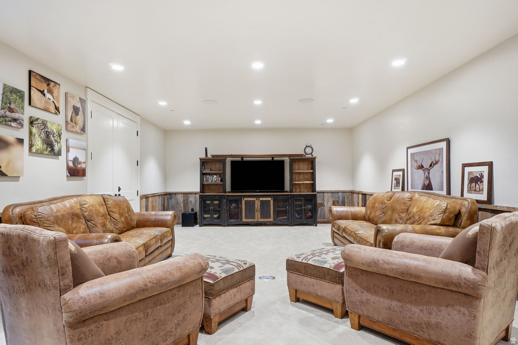 Spacious recreation room featuring recessed lighting, light-toned walls, and a rustic wood-paneled accent wall