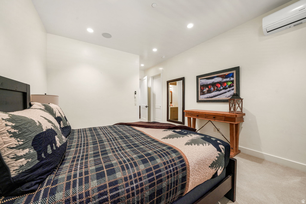 Bedroom featuring recessed lighting, a wall-mounted mini-split HVAC unit, and plush carpet flooring