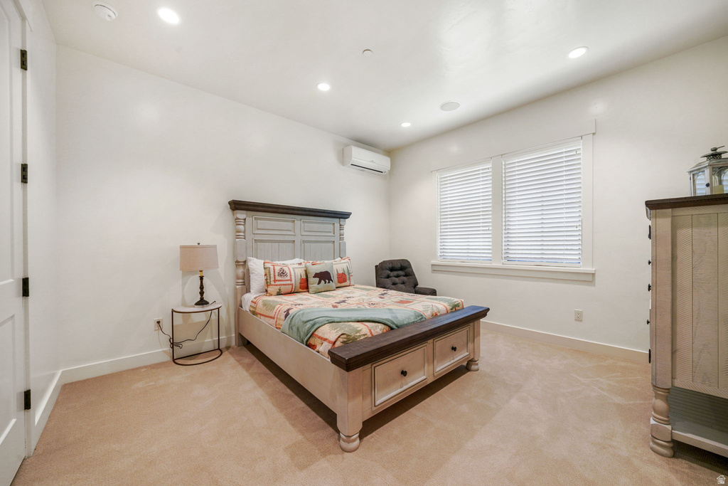 Carpeted room featuring recessed lighting, a split-system air conditioning unit, and two windows with blinds