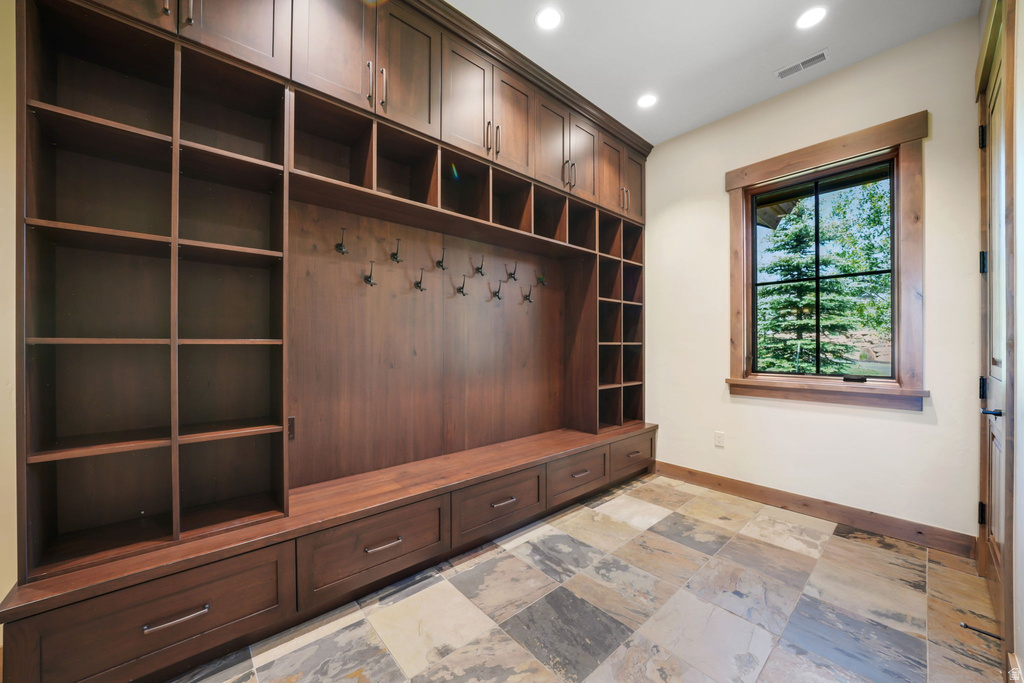 Custom built-in storage system with a rich wood finish, featuring open shelving, cubbies, and integrated drawers