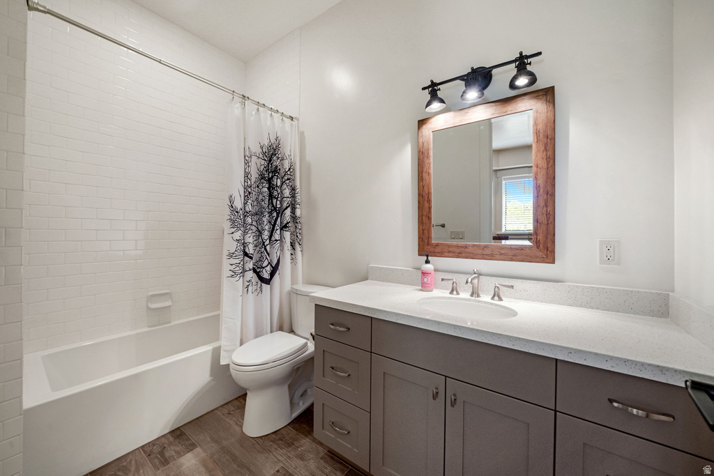 Bathroom featuring a single vanity with an integrated sink, a light-toned countertop, and a wood-finish framed mirror