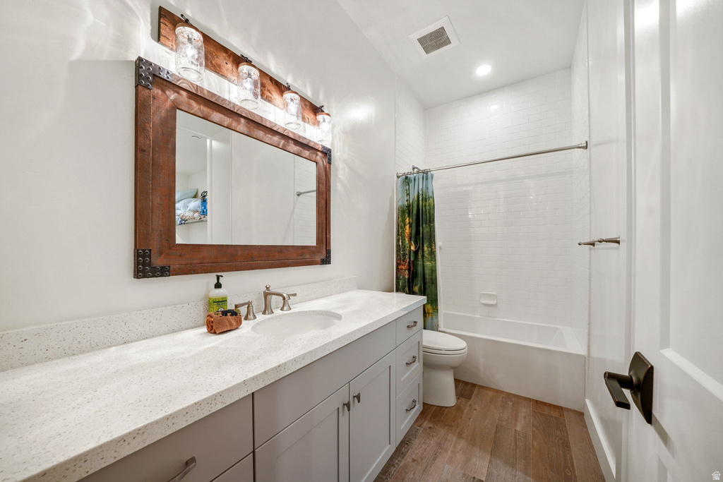 Bathroom featuring a single vanity with light grey cabinetry, white speckled countertop, and an undermount sink
