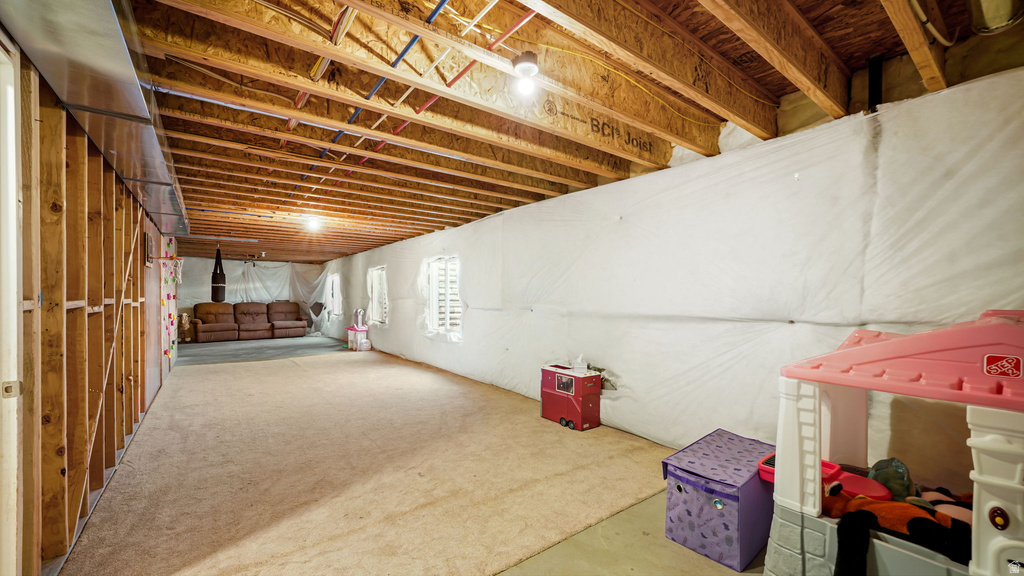 Expansive lower level with exposed joist ceiling and unfinished wood framing