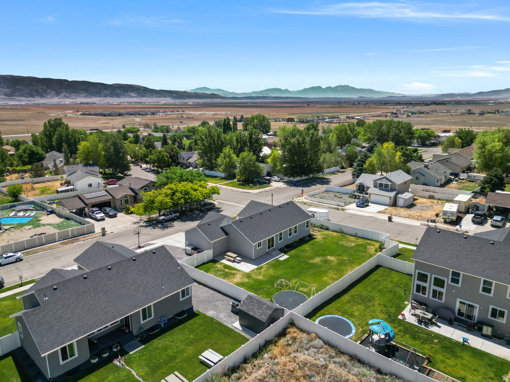 Expansive residential area featuring numerous single-family homes, mature trees, and mountainous terrain in the distance