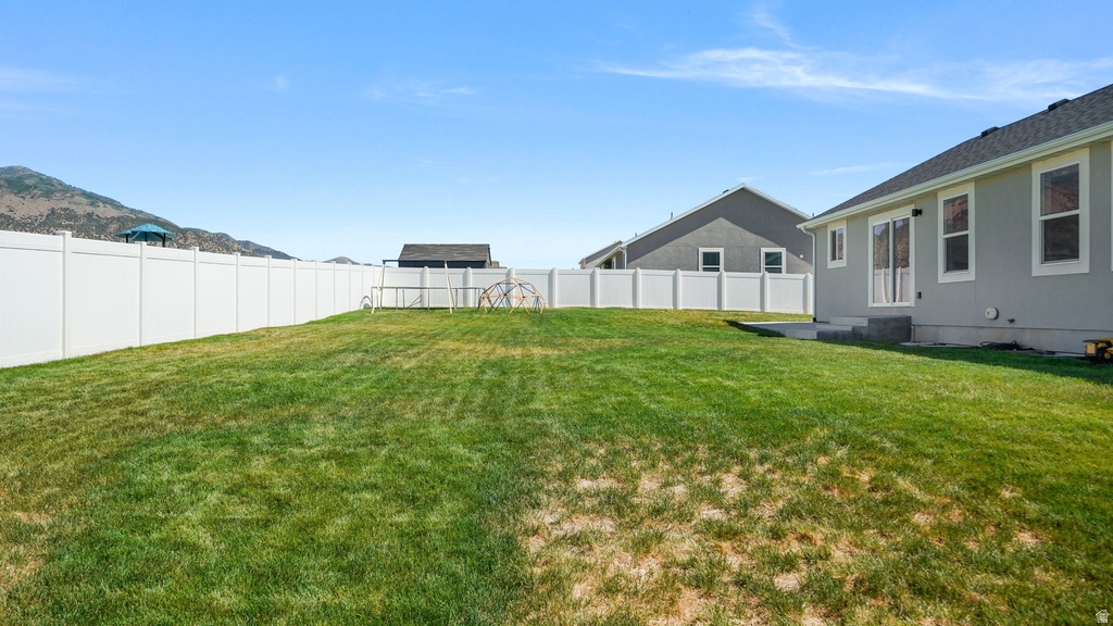 Expansive lawn bordered by a white privacy fence