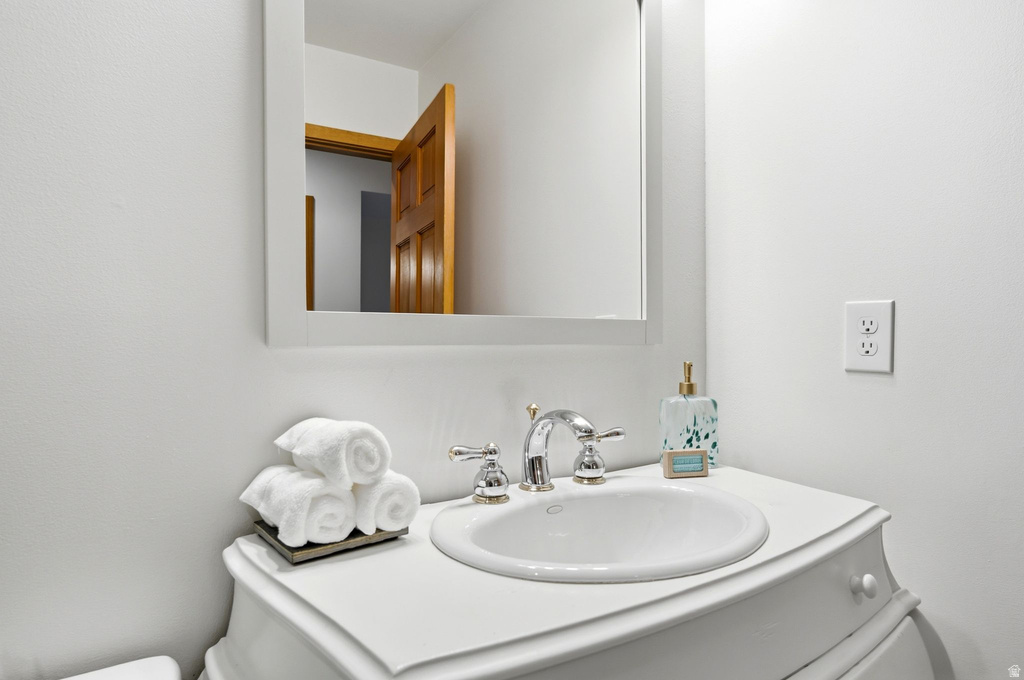 White vanity with an integrated basin and a chrome faucet, complemented by a framed wall mirror