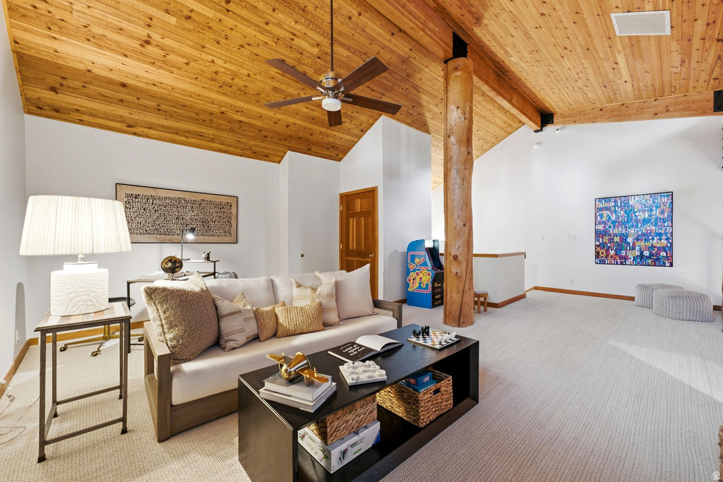 Sloped wood-paneled ceiling with exposed wood beams and a ceiling fan
