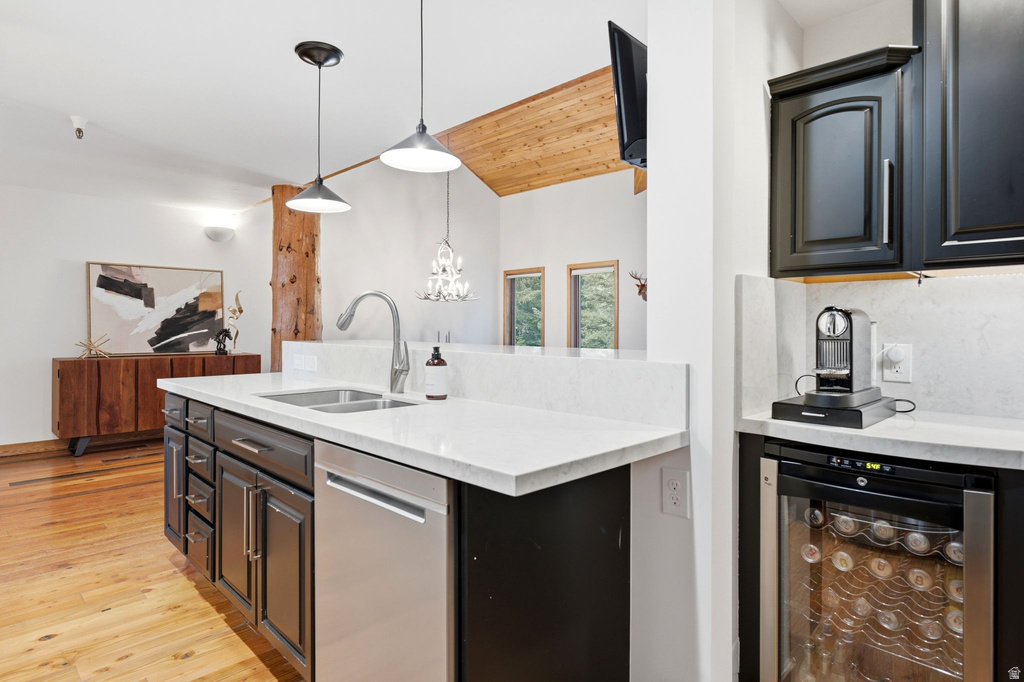 Kitchen island featuring a dual-basin stainless steel sink with a gooseneck faucet, a stainless steel dishwasher, and white countertops