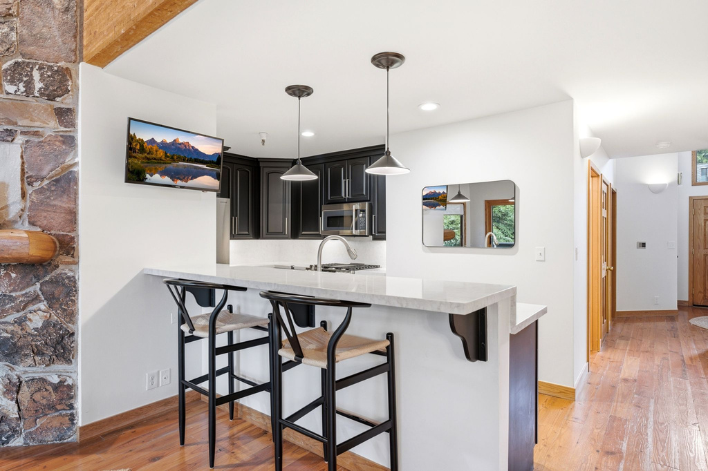 Kitchen island featuring a light-toned countertop and two pendant lights