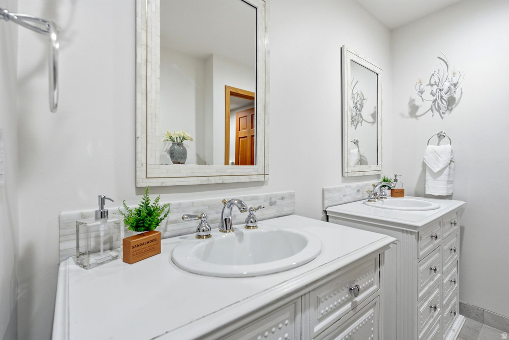 Dual vanity featuring white cabinetry with decorative detailing, white countertops, and chrome fixtures
