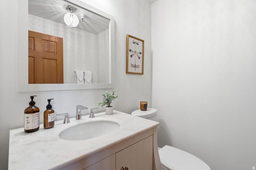 Bathroom featuring a single vanity with a white countertop, undermount sink, and chrome faucet
