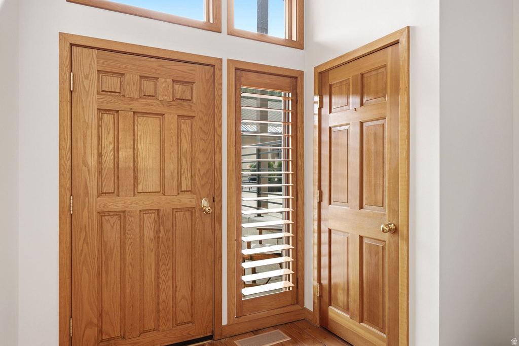 Entryway featuring a paneled wood door, coordinating wood trim, and a sidelight with louvered shutters