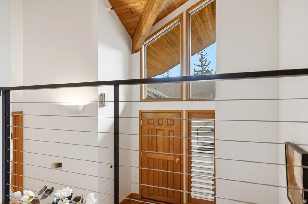 Vaulted ceiling featuring exposed wood beams and architectural windows