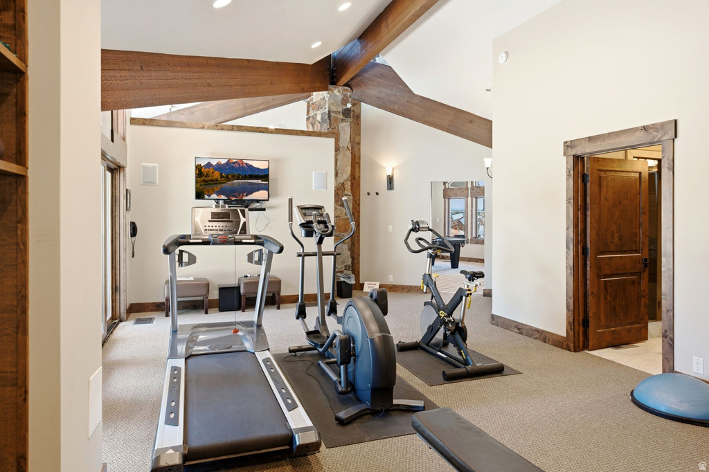 Dedicated fitness space featuring exposed wood beams and architectural stone accents