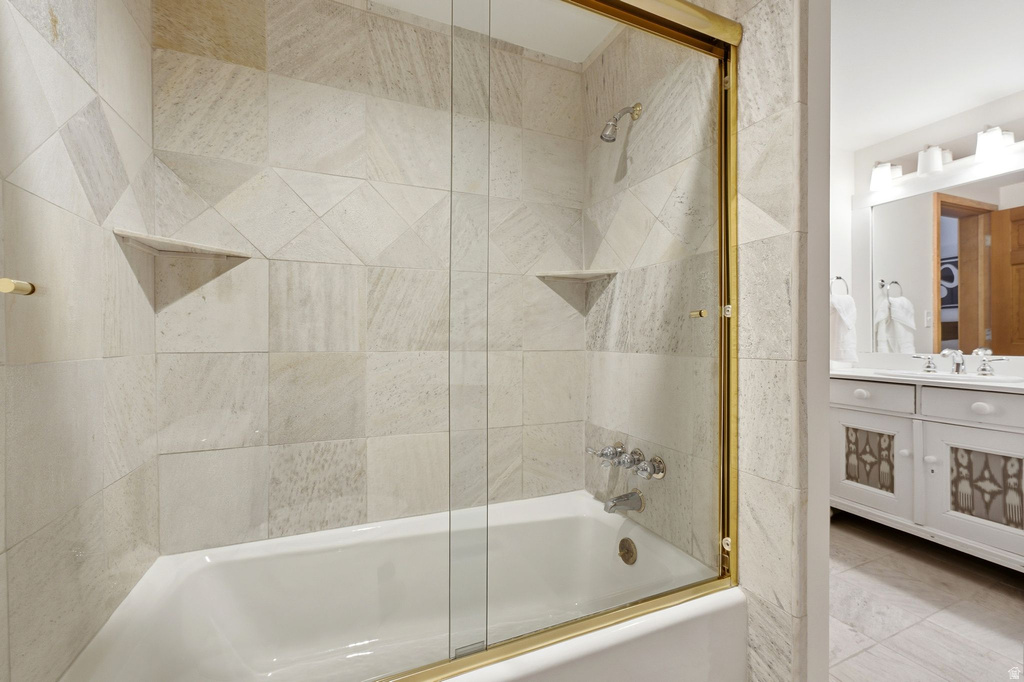 Bathtub shower with glass enclosure and brass-finish hardware