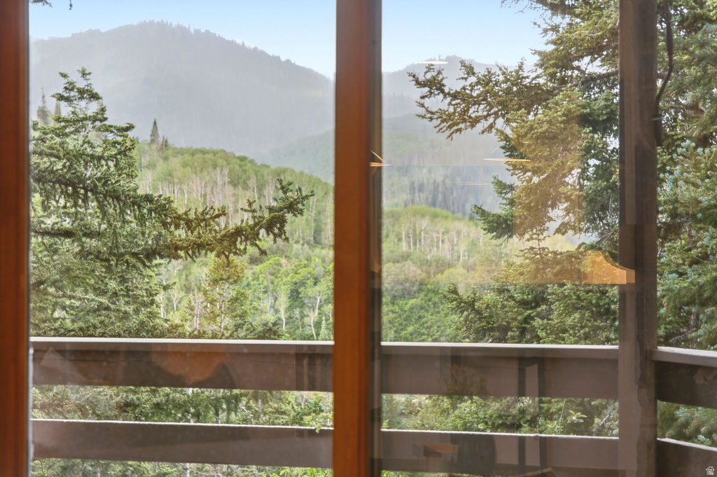 Expansive mountain scenery visible through large windows and a wood-framed balcony railing