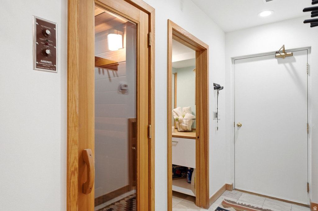 Interior sauna with a glass-paneled wood door and adjacent control panel