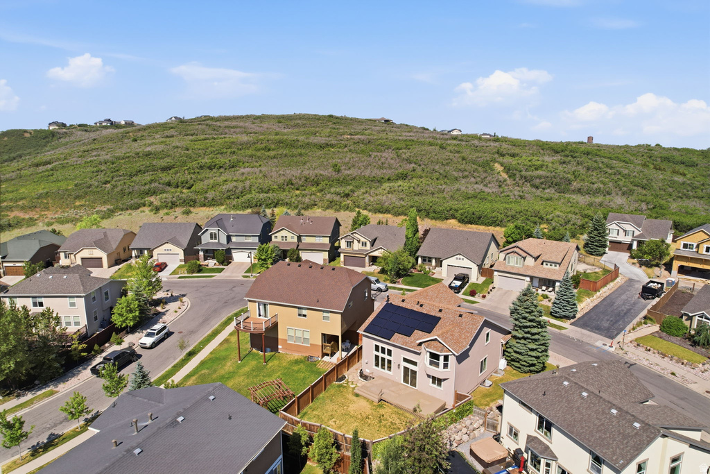 Residential area featuring diverse architectural styles and mature landscaping, set against a backdrop of a verdant hillside