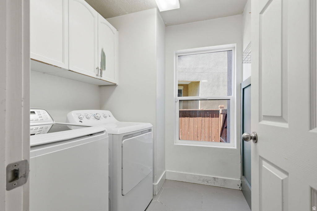 Utility room featuring white cabinetry, a single window, and a paneled door