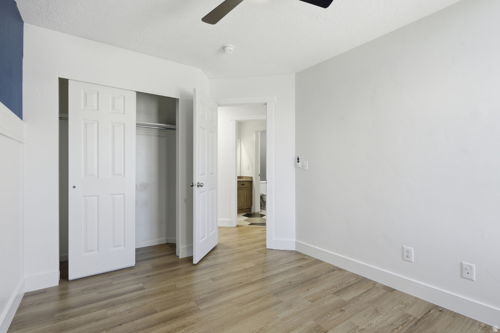 Interior room featuring wood-finish flooring, white baseboards, and a contrasting blue accent wall with wainscoting
