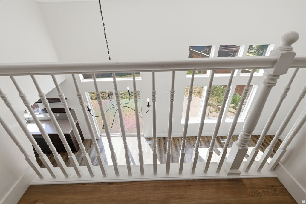 White spindle railing overlooking a living space with wood-finish flooring