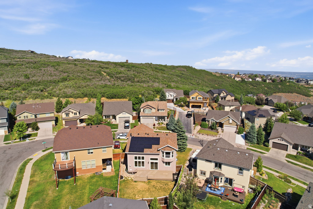 Residential neighborhood featuring diverse architectural styles, hillside setting, paved streets, and a mix of mature and young trees