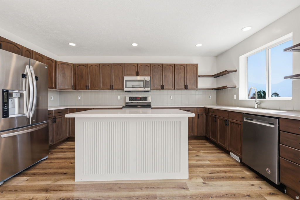 Kitchen featuring a central island with beadboard paneling, wood-finish flooring, and recessed lighting