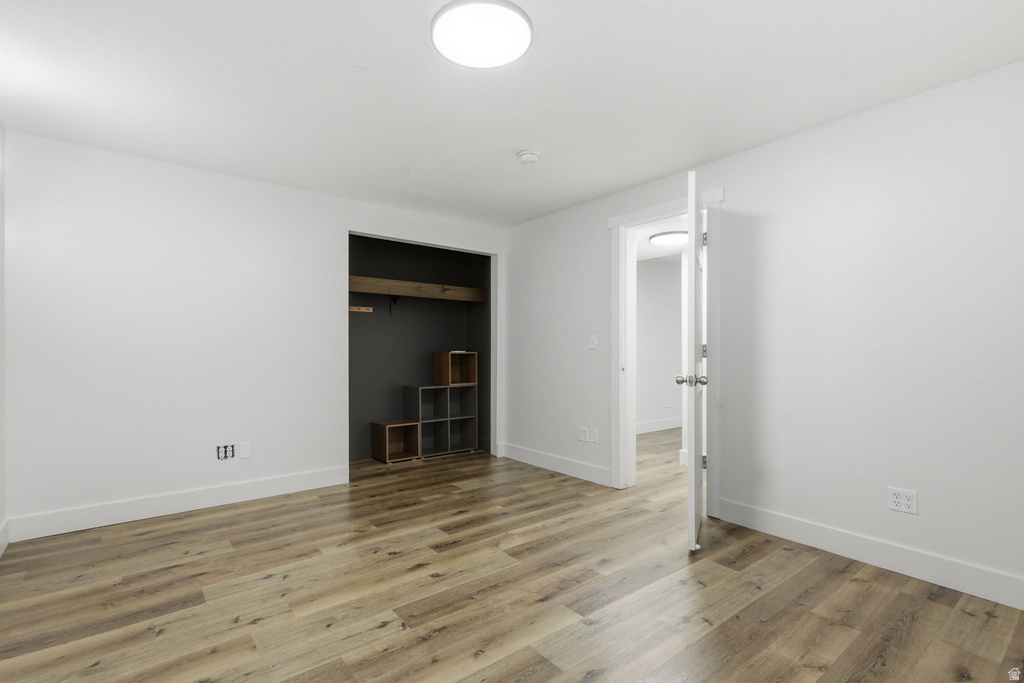 Bright room featuring wood-finish flooring, white baseboards, and neutral wall paint