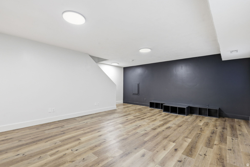 Spacious room featuring wood-finish flooring and recessed lighting