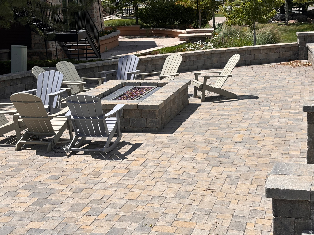 Expansive paver patio featuring a stone-clad fire pit