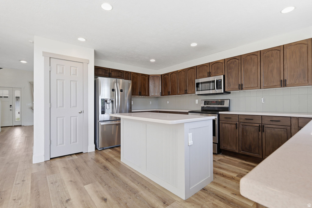 Kitchen featuring wood-finish flooring, recessed lighting, and a white beadboard island
