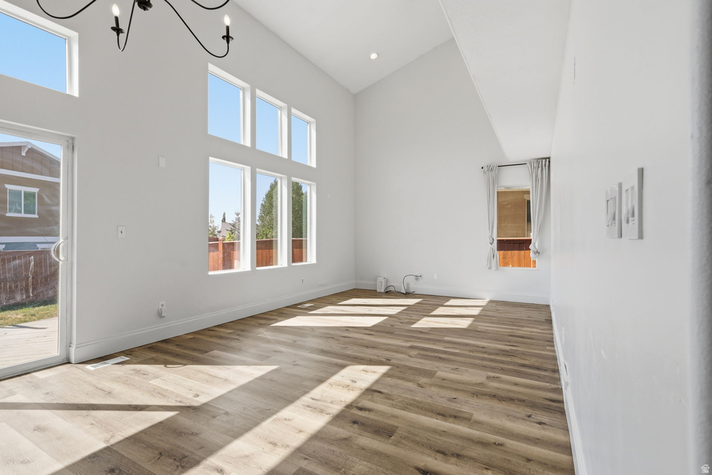 Open-concept living area featuring a vaulted ceiling and wood-finish flooring