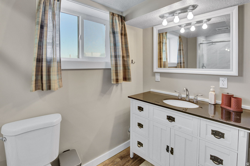 Bathroom featuring a white vanity with dark countertop, an undermount sink, and chrome fixtures