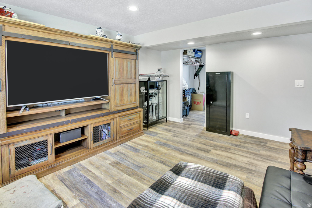 Spacious room featuring wood-finish flooring, recessed lighting, and light gray wall paint