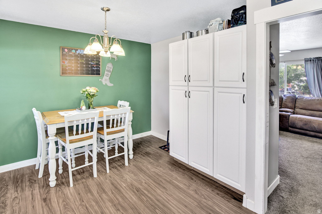 Dedicated dining area featuring wood-finish flooring and a contemporary chandelier